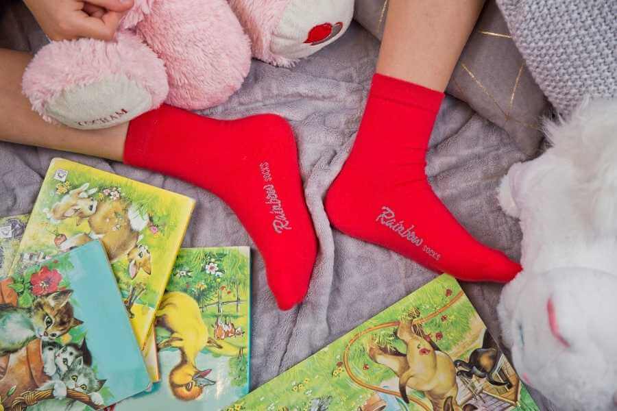 A kid in red socks playing rainy day family game